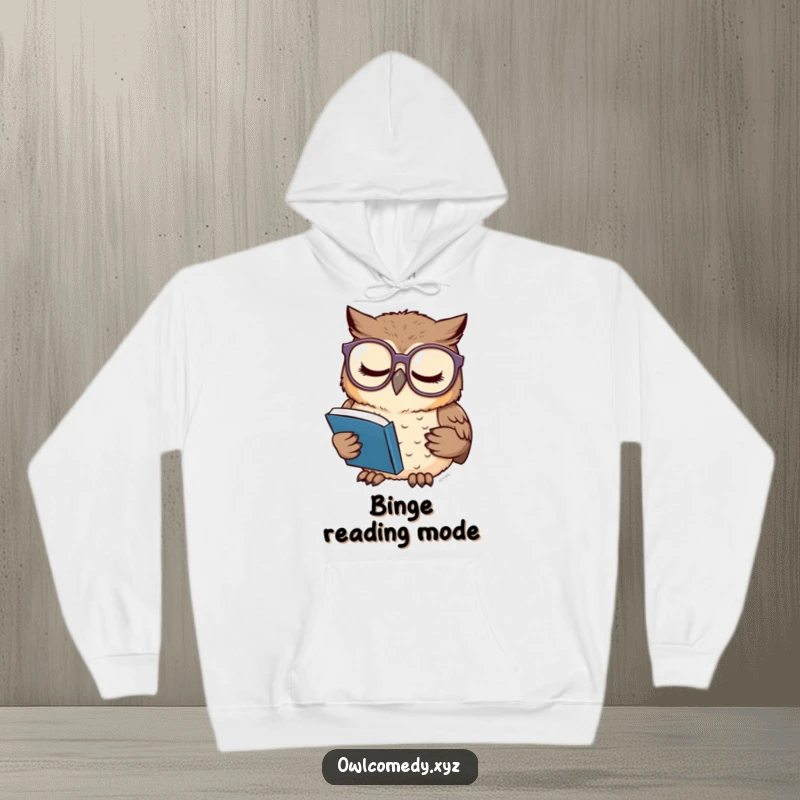 Funny and cozy hoodie featuring a sleepy owl wearing large glasses, concentrating intently on a tiny book, ideal for readers.