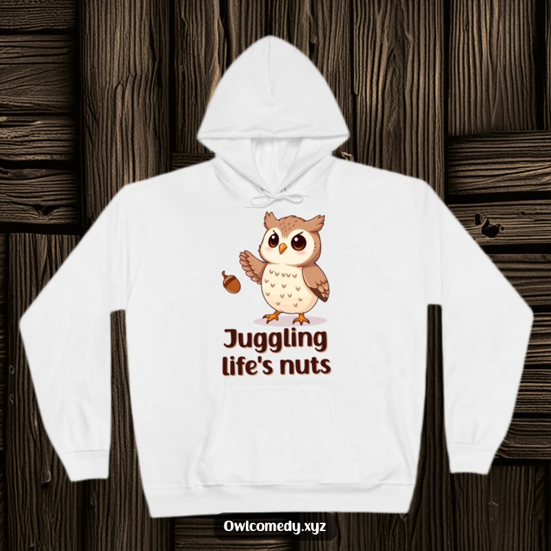 Funny hoodie with a design of a playful owl juggling numerous small acorns with its talons, perfect for cozying up.